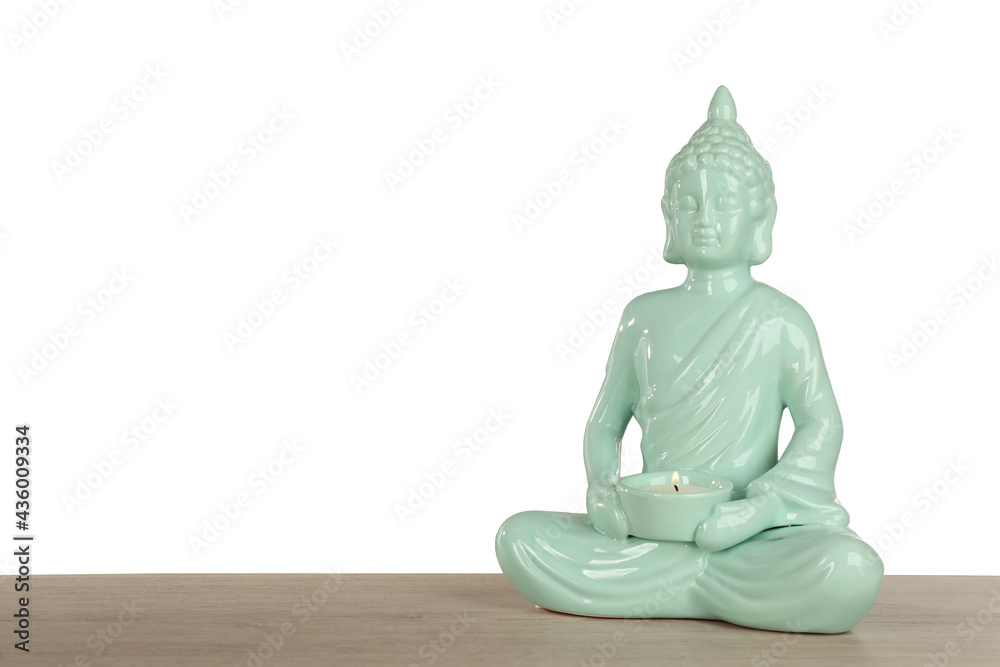 Beautiful ceramic Buddha sculpture with burning candle on wooden table against grey background. Space for text Beautiful ceramic Buddha sculpture with burning candle on wooden table against grey background. Space for text