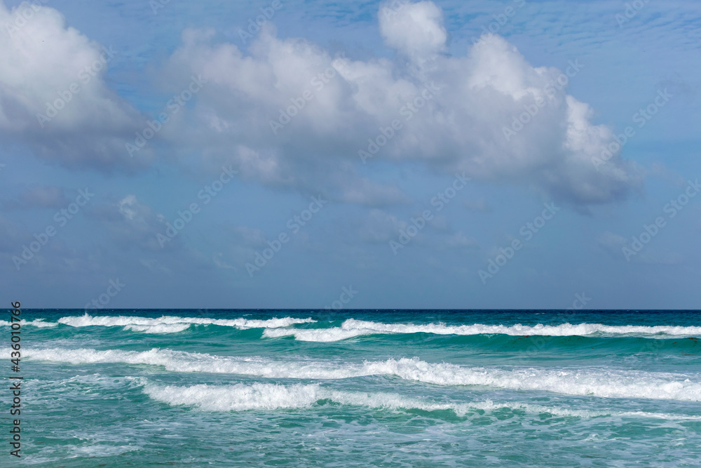 landscape of waves on the beach with blue sky and clouds