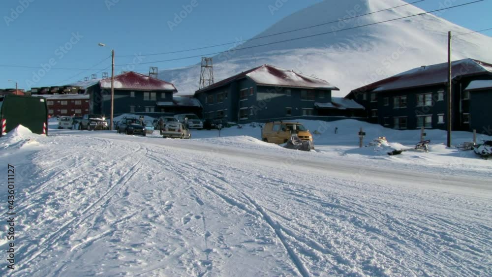 LONGYEARBYEN, SVALBARD - 23 APRIL, 2015: Landscape and buildings, roads in Small town Longyear among snow capped mountains of Norwegian archipelago of Svalbard in early spring in Norway. LONGYEARBYEN, SVALBARD - 23 APRIL, 2015: Landscape and buildings, roads in Small town Longyear among snow capped mountains of Norwegian archipelago of Svalbard in early spring in Norway.