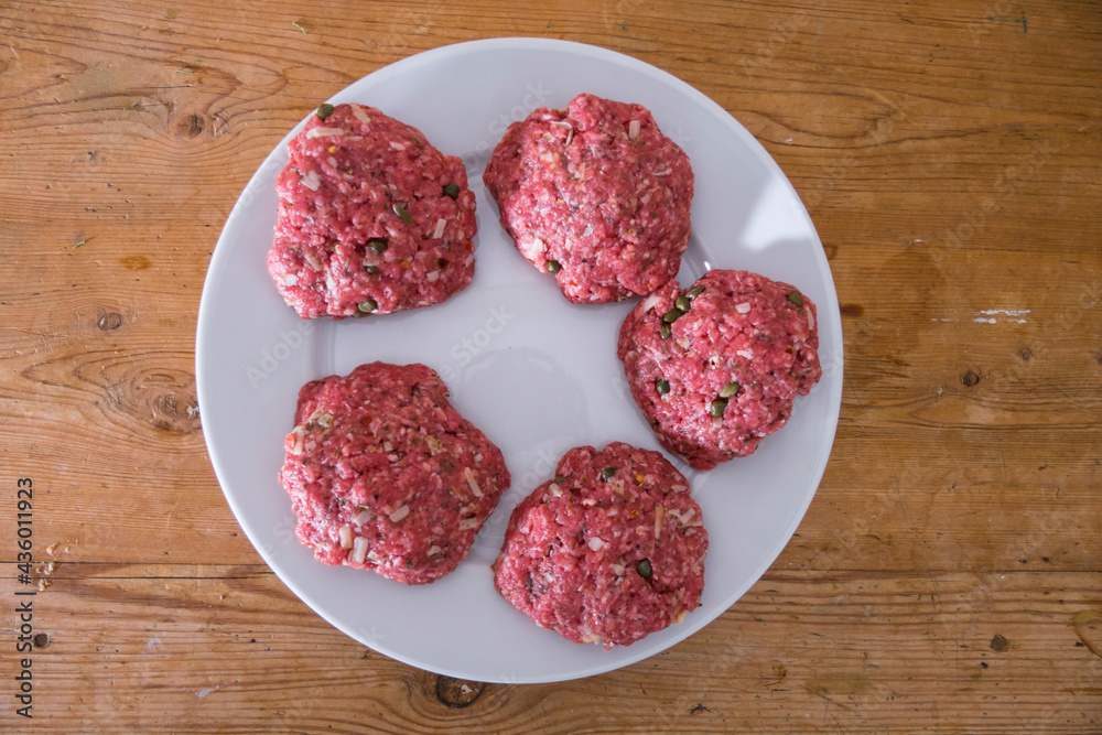 Raw hamburgers on a plate. Raw hamburgers on a plate.
