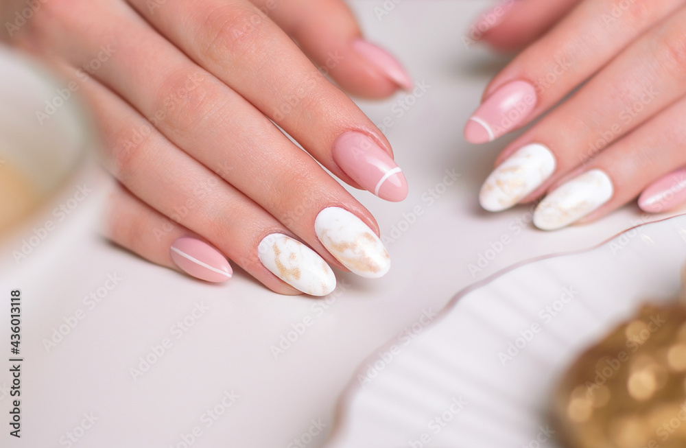 Beautiful female hands with luxury manicure nails, pink and white gel polish
