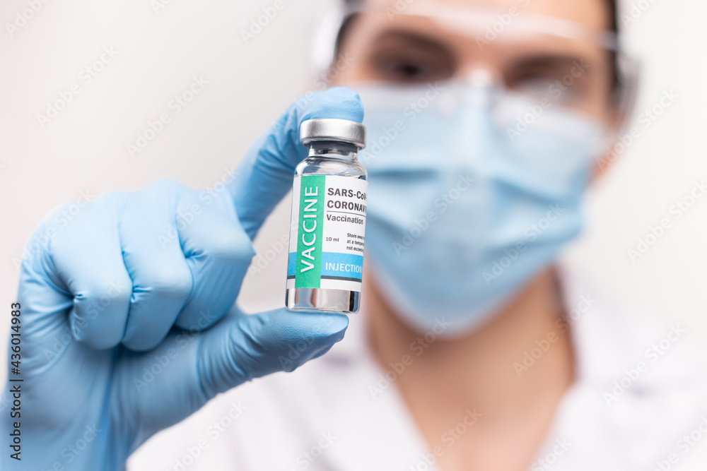 SARS - CoV2 Vaccination concept. Close up COVID-19 vaccine dose. A doctor or nurse in a laboratory holds a vial with a vaccine. Pandemic immunity. SARS - CoV2 Vaccination concept. Close up COVID-19 vaccine dose. A doctor or nurse in a laboratory holds a vial with a vaccine. Pandemic immunity.