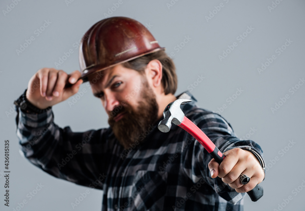 bearded male hipster in checkered shirt and laborer helmet, selective focus, hammer bearded male hipster in checkered shirt and laborer helmet, selective focus, hammer