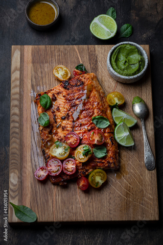 Grilled salmon with tomato salad and avocado sauce