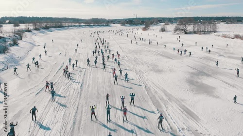 Many people on ski race competition in covered snow winter forest. Aerial view. cross-country skiing