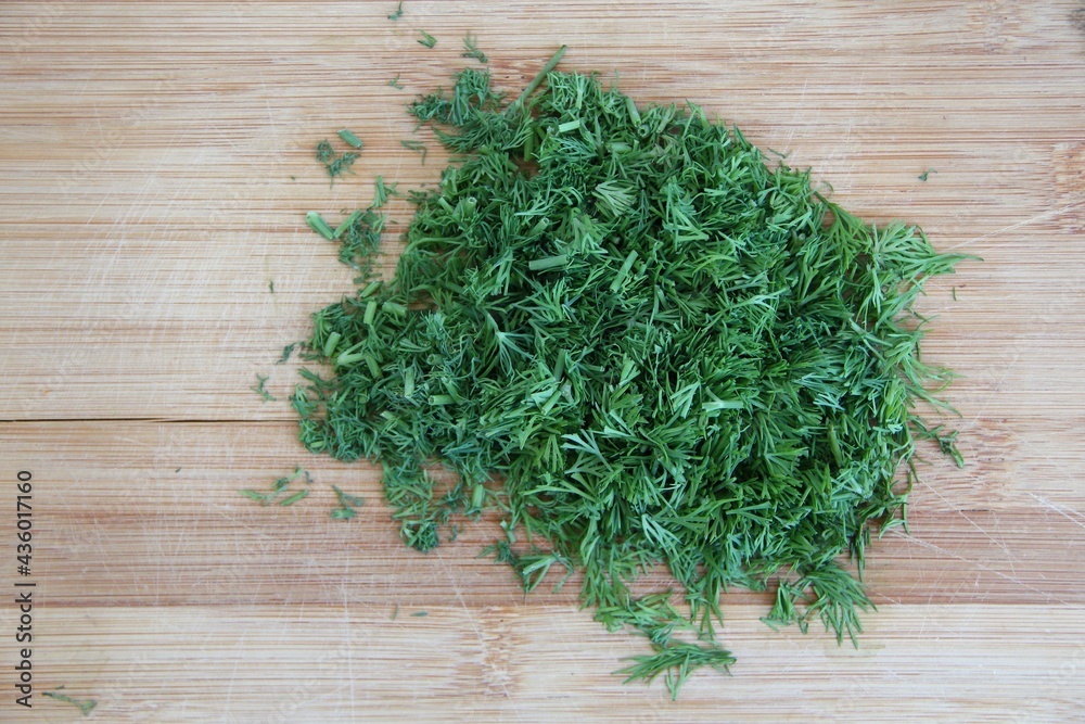 Chopped dill on the wooden cutting board, close-up Chopped dill on the wooden cutting board, close-up