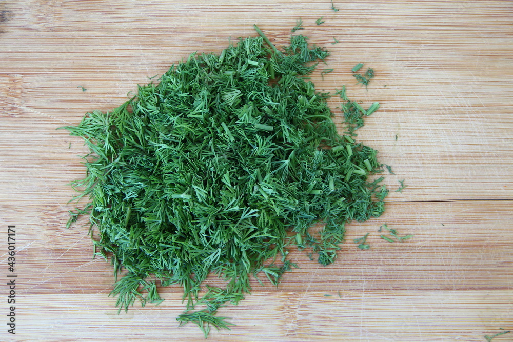 Chopped dill on the wooden cutting board, close-up Chopped dill on the wooden cutting board, close-up