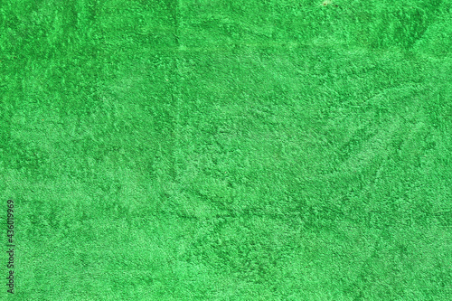 Green beach towel. Part of a terry towel.Background.