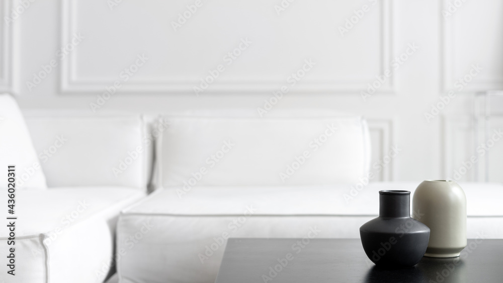 Grey vases on black tea table near couch Grey vases on black tea table near couch