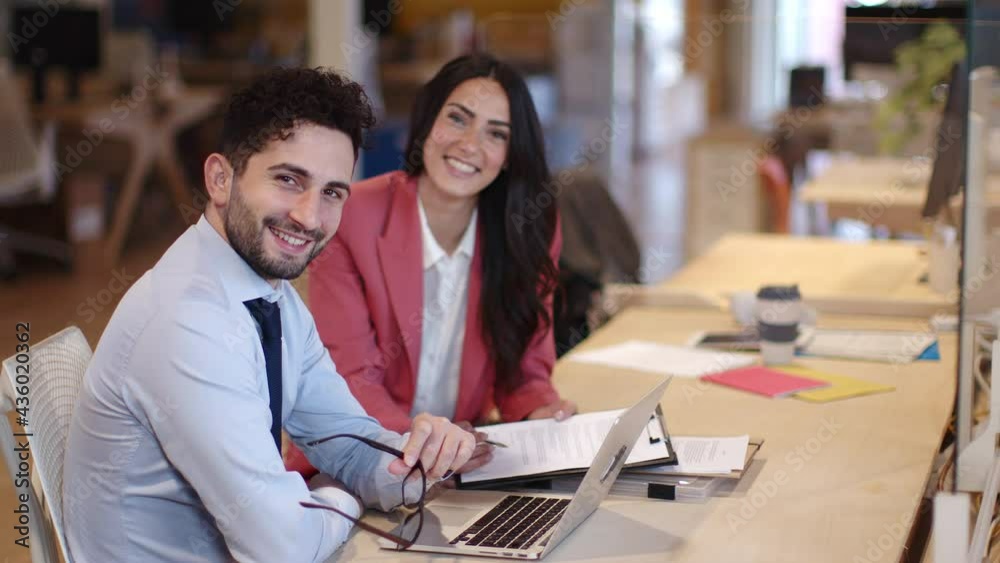 Happy business people working in office, looking at camera Happy business people working in office, looking at camera