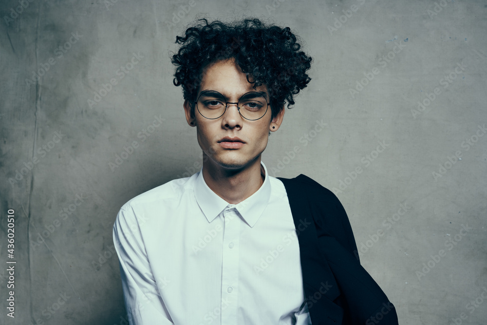 young guy with glasses curly hair jacket shirt portrait close-up