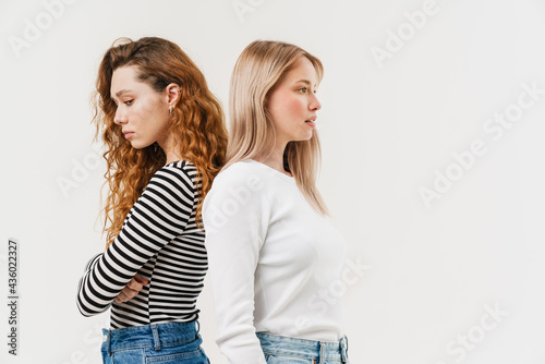 Young two women standing back to back after argument