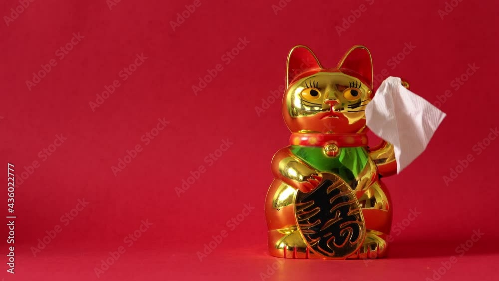 Sitting Maneki-neko cat waving goodbye with tissue Sitting Maneki-neko cat waving goodbye with tissue