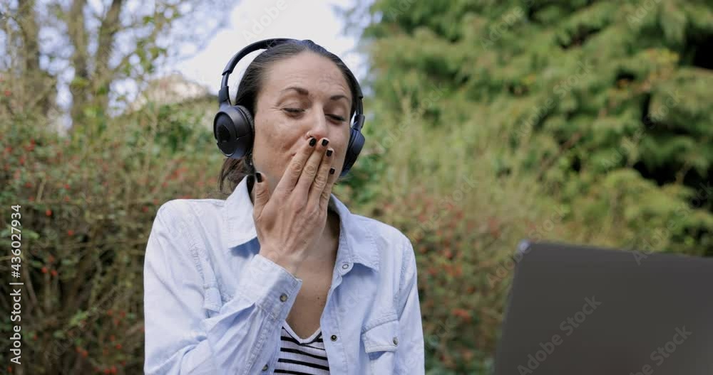 Woman with headphones ending video call with blow kiss Woman with headphones ending video call with blow kiss