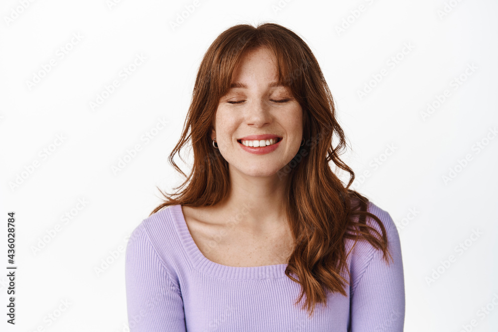 Portrait of dreamy girl, smiling and close eyes, remember something beautiful, imaging something, daydreaming, standing in purple blouse against white background Portrait of dreamy girl, smiling and close eyes, remember something beautiful, imaging something, daydreaming, standing in purple blouse against white background