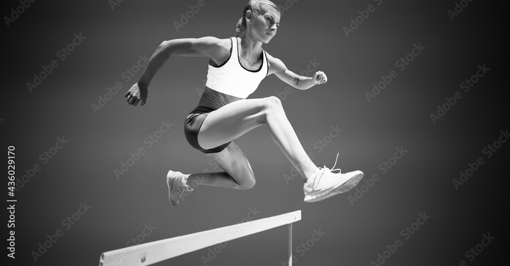 Fototapeta premium Composition of female hurdle jumper with copy space in black and white