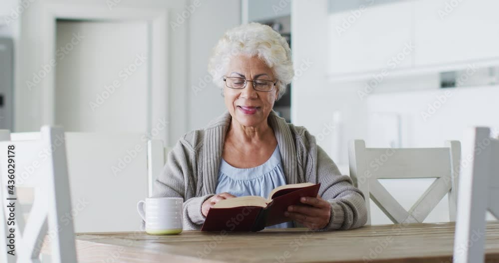 African american senior woman reading a book while sitting at home African american senior woman reading a book while sitting at home