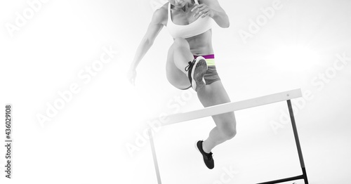 Composition of female athlete hurdle jumping with copy space on white background