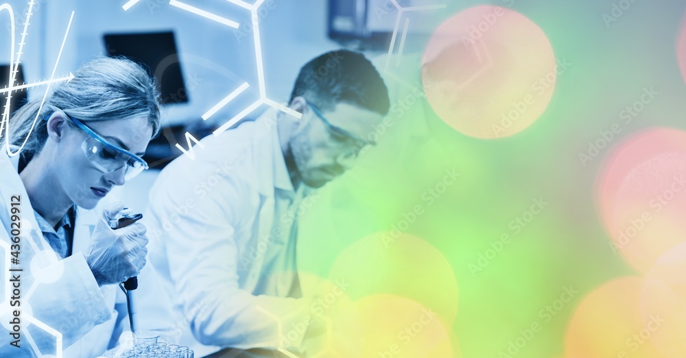 Composition of male and female lab technicians at work, with colourful bokeh copy space to right Composition of male and female lab technicians at work, with colourful bokeh copy space to right