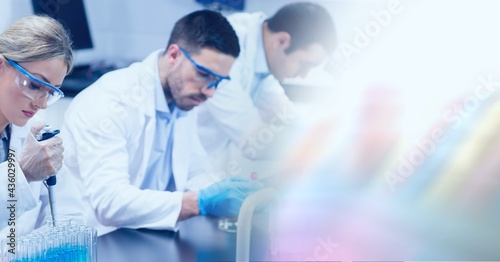 Composition of male and female lab technicians at work, with blurred copy space to right