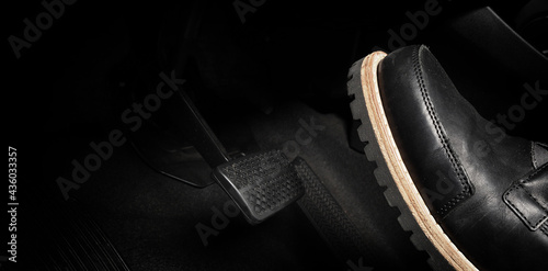 Foot pressing foot pedal of a car to drive. Accelerator and brake pedal in a car. Driver driving the car by pushing accelerator and break pedals of the car. inside vehicle. control pedal. Close up. © gnepphoto