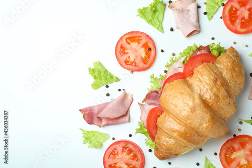 Croissant sandwich and ingredients on white background, space for text