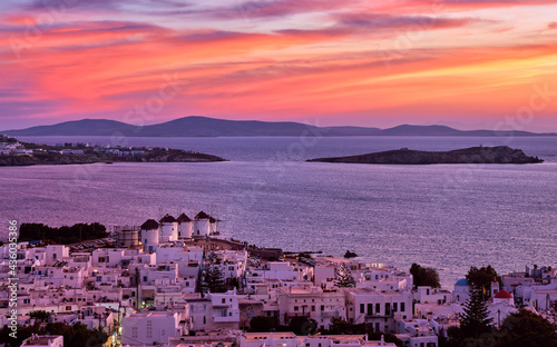 Beautiful sunset view, famous traditional white windmills on hilltop, Mykonos, Greece. Whitewashed house, summer, iconic Mediterranean destination