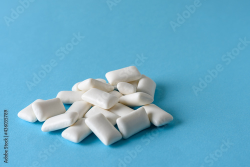 Heap of chewing gum with e171 on blue background photo