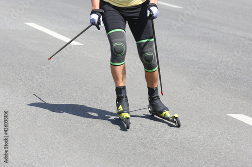 sportsman roller skis on the asphalt on the city road. Sports leisure