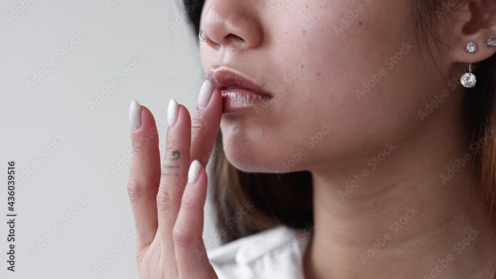 Nude makeup. Stylish look. Take care cosmetic. Beauty salon. Unrecognizable asian woman touching lips with pastel glossy lipstick isolated white copy space. Nude makeup. Stylish look. Take care cosmetic. Beauty salon. Unrecognizable asian woman touching lips with pastel glossy lipstick isolated white copy space.