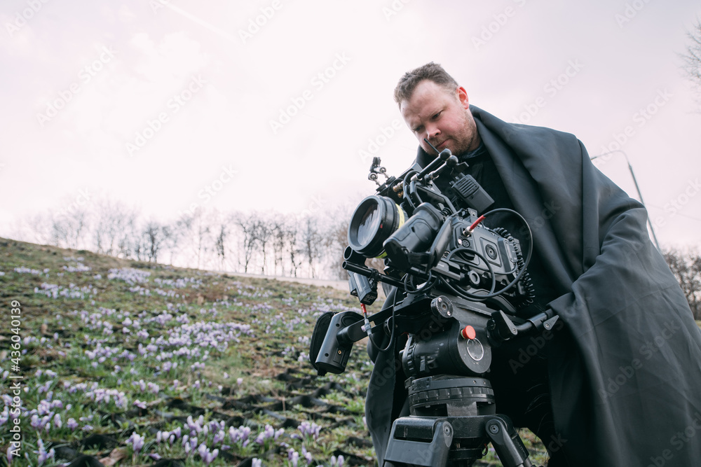 Director of photography with a camera in his hands on the set. Professional videographer at work on filming a movie Director of photography with a camera in his hands on the set. Professional videographer at work on filming a movie