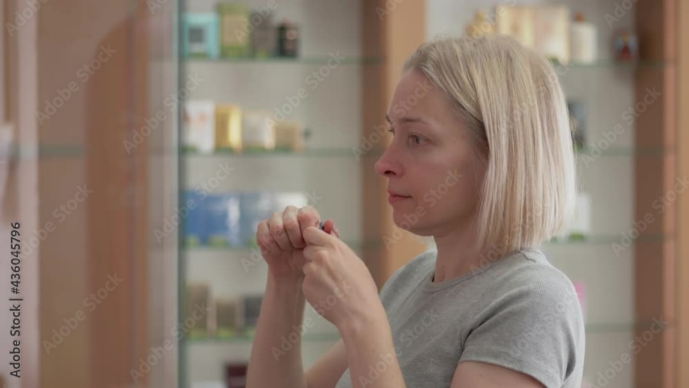 A woman tries the fragrance of perfume in a store. A woman tries the fragrance of perfume in a store.