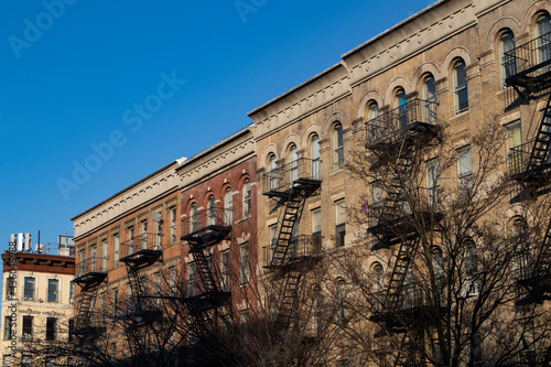 Row of Old Brick Residential Buildings with Fire Escapes on the Upper West Side of New York City