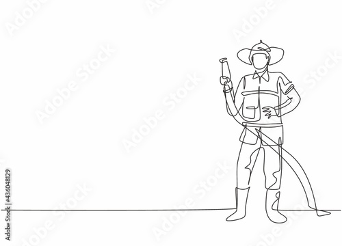 Single one line drawing of young fireman pose standing and holding water nozzle. Professional work profession and occupation minimal concept. Continuous line draw design graphic vector illustration