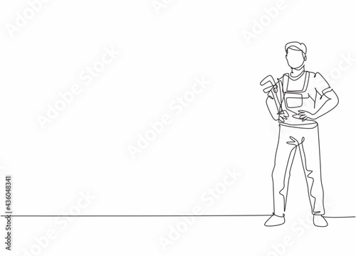 Single continuous line drawing of young male plumber pose standing ang holding pipe wrench. Professional work job occupation. Minimalism concept one line draw graphic design vector illustration