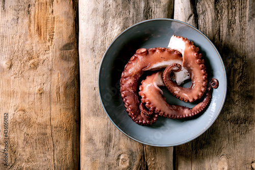 Coocked tentacles of octopus on ceramic plate photo