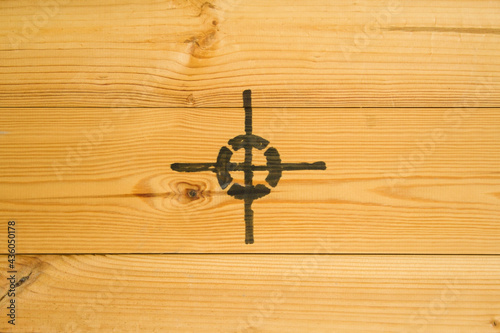 Transport sign, symbol for the center, against a background of yellow boards. The sign is located in the center in close-up. Three boards are nailed together horizontally, not painted. 
