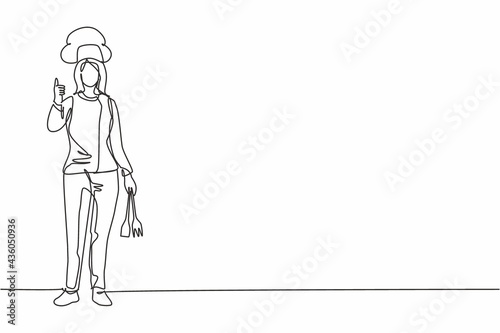 Single continuous line drawing female chef stands with a thumbs-up gesture and the cooking uniform prepares the ingredients to cook the best dishes. One line draw graphic design vector illustration
