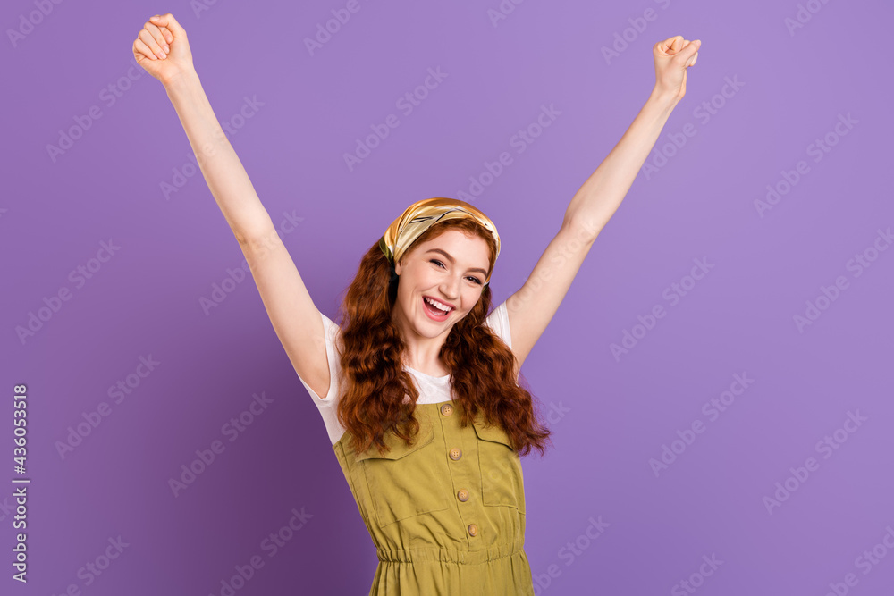 Photo of happy triumphant young woman raise fists good mood winner yes isolated on purple color background Photo of happy triumphant young woman raise fists good mood winner yes isolated on purple color background