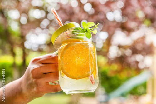 a person holding non-alcoholic fruity summer drink