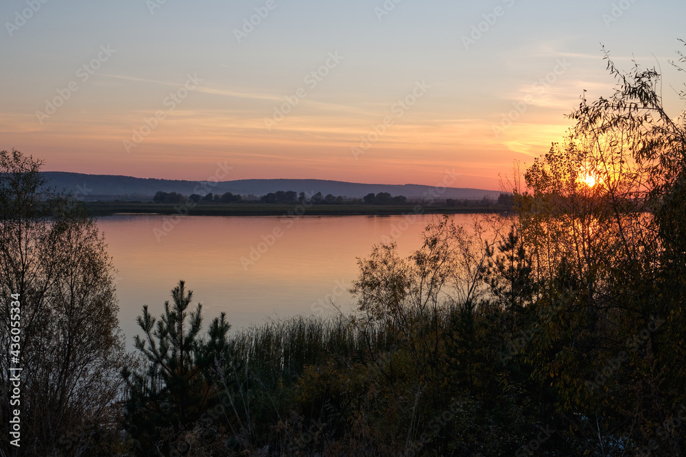 Landscape, sunset, beautiful sky. Lake shore with trees. Summer.