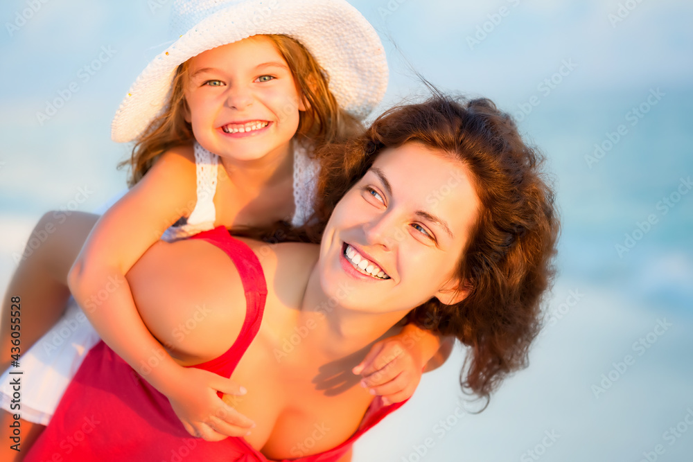 Portrait of happy mother and little daughter on sunny beach on Maldives at summer vacation. Family on the beach concept.