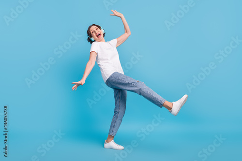Full length body size photo elder woman dancing in headphones enjoying party isolated pastel blue color background