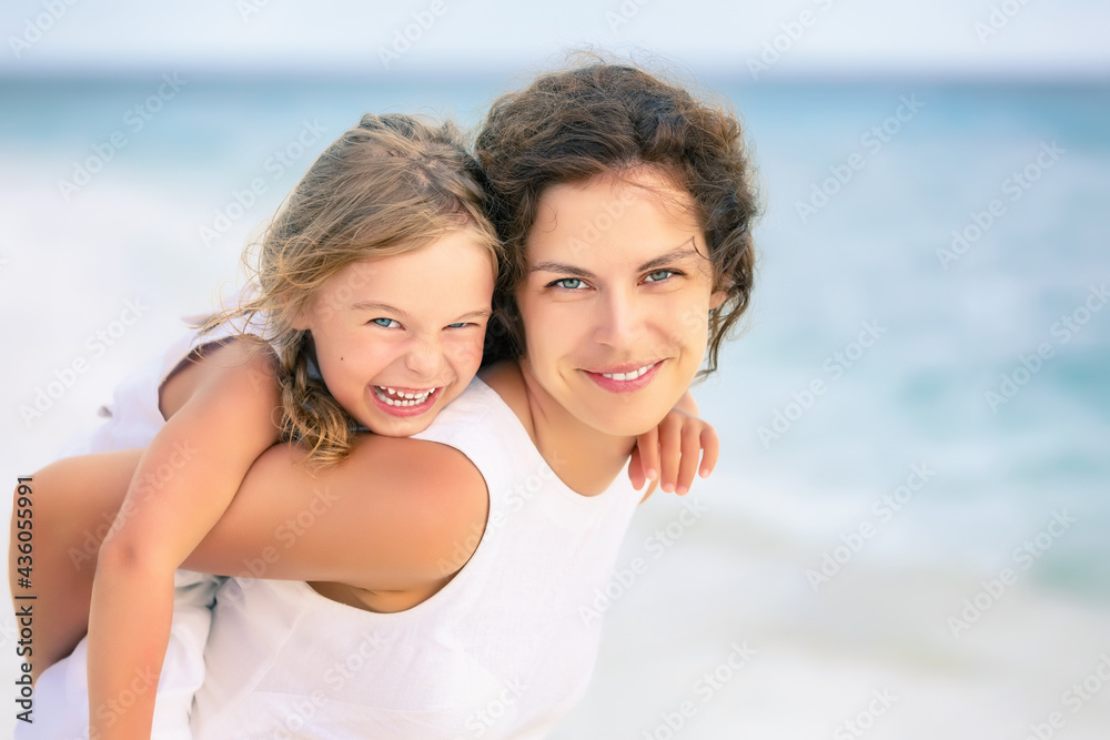 Portrait of happy mother and little daughter on ocean beach on Maldives at summer vacation. Family on the beach concept. Portrait of happy mother and little daughter on ocean beach on Maldives at summer vacation. Family on the beach concept.