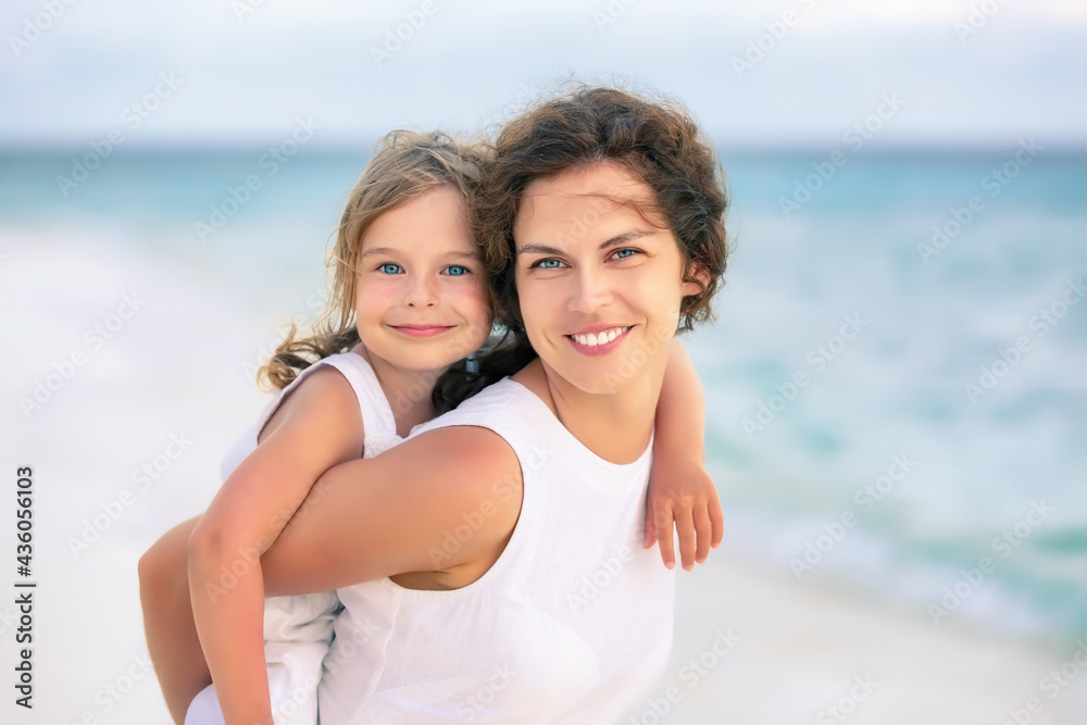 Portrait of happy mother and little daughter on ocean beach on Maldives at summer vacation. Family on the beach concept. Portrait of happy mother and little daughter on ocean beach on Maldives at summer vacation. Family on the beach concept.