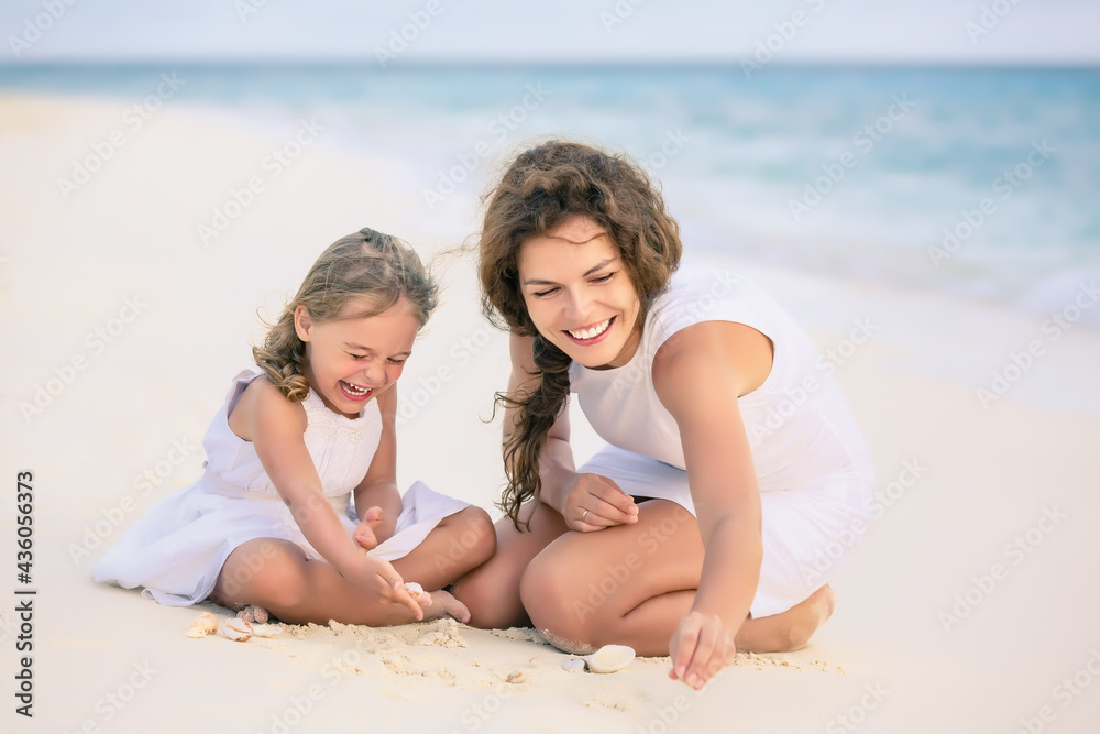 Mother with little daughter playing on ocean beach, Maldives. Family on the beach concept. Mother with little daughter playing on ocean beach, Maldives. Family on the beach concept.