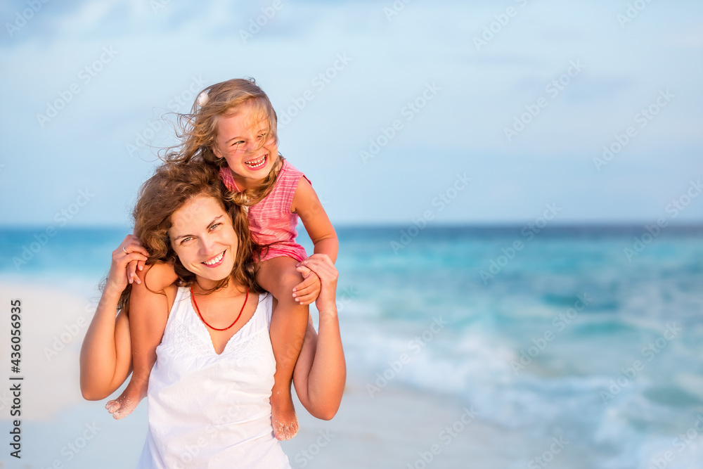 Happy mother and little daughter having fun on beach on Maldives at summer vacation. Family on the beach concept. Happy mother and little daughter having fun on beach on Maldives at summer vacation. Family on the beach concept.