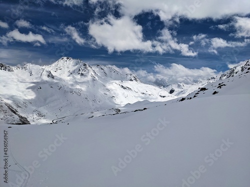 ski tour in the beautiful mountains of grisons. Winter adventure hike in the mountains with lots of snow. Blue sky sun