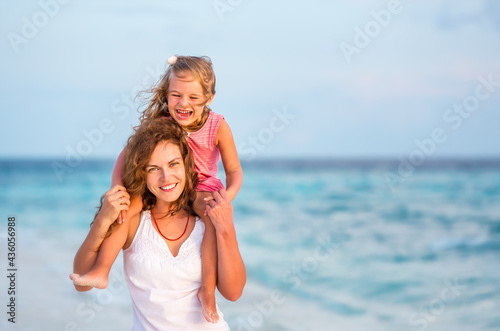 Happy mother and little daughter having fun on beach on Maldives at summer vacation. Family on the beach concept.