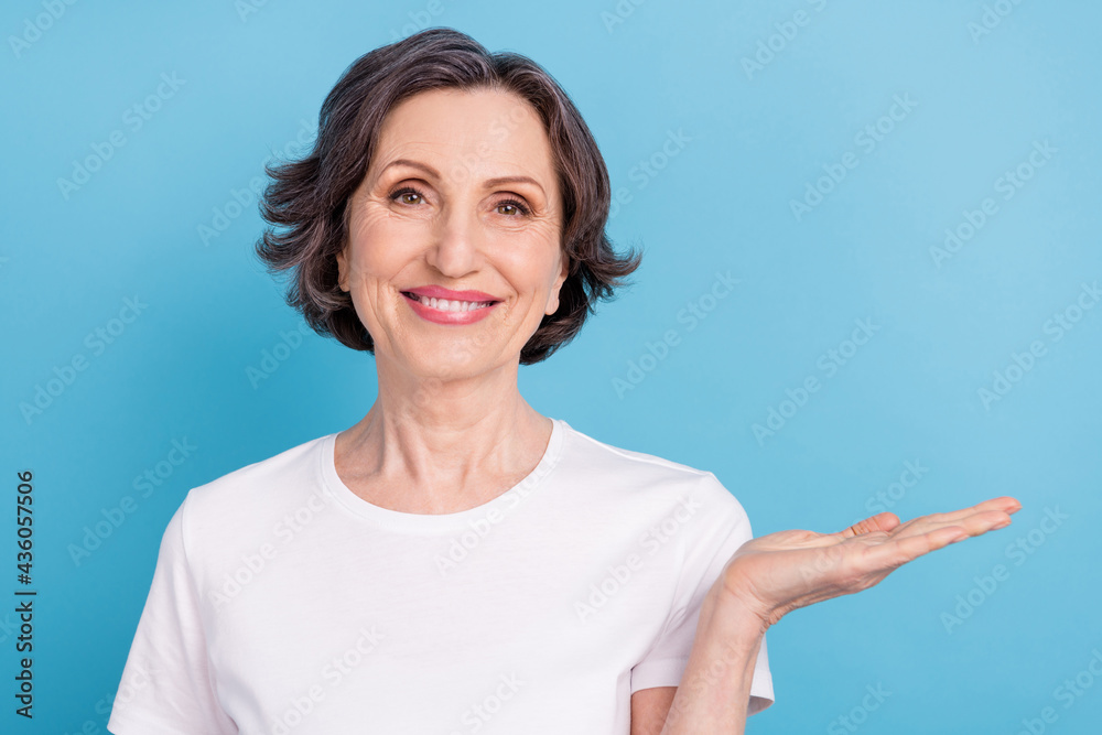 Photo portrait woman keeping blank space on palm smiling isolated pastel blue color background Photo portrait woman keeping blank space on palm smiling isolated pastel blue color background